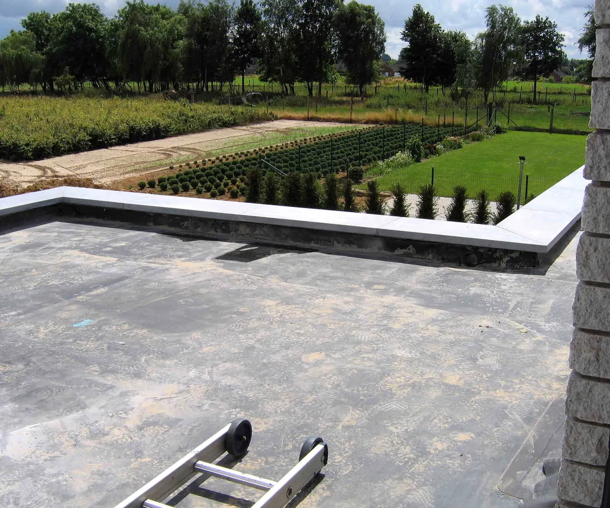 Black EPDM rubber flat roof running up to a capped parapet wall