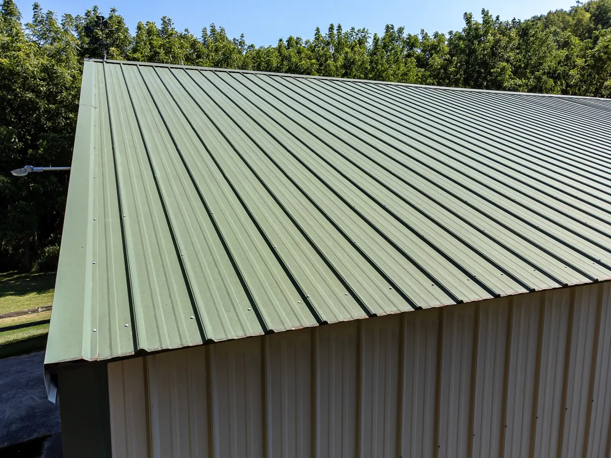 Corrugated metal roof panels with rows of exposed screws and washers